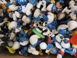 a lot of smurfs that are in a cardboard box