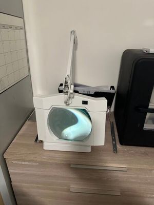 des toilettes sur lesquelles est allumée une lumière bleue, à côté d'une imprimante noire