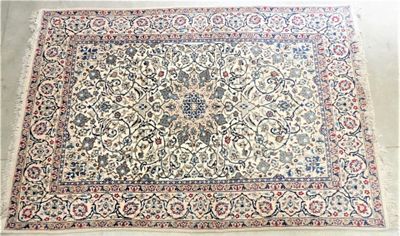 un grand tapis persan à motifs floraux sur fond blanc