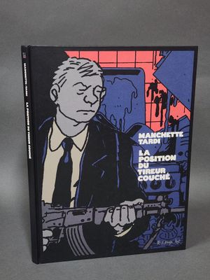 un livre sur lequel figure la photo d'un homme en costume-cravate tenant un pistolet