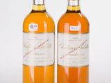 deux bouteilles de vin posées l'une à côté de l'autre sur une surface blanche