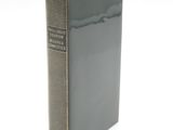 an old book sitting on top of a white table next to a white wall