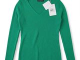 a women ' s green sweater with a white tag on it