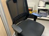 a black office chair in a room with a computer desk