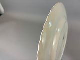 a white plate with a gold rim sitting on a table