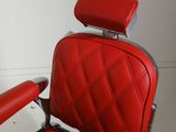an image of a red barber chair in the corner of a room