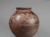 a brown vase sitting on a table with a gray background