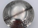 an antique silver plate with a floral design on it