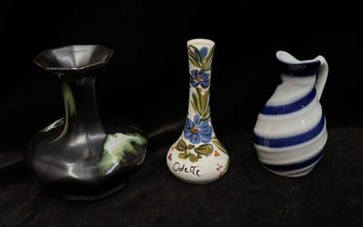 three vases that are sitting on a black surface
