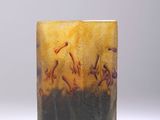 un vase en verre avec un tableau posé sur une table