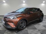 une Toyota C-HR marron garée dans une pièce au sol à damier