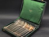 a green case with silverware in it on a black background