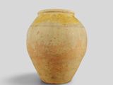a yellow vase sitting on a white surface with a gray background