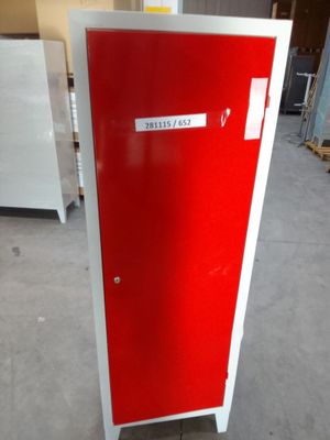 a red and white refrigerator in a warehouse with a sign on the door