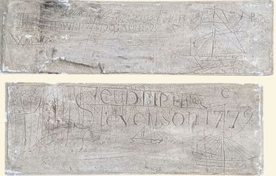 two pieces of stone with writing on them on a white surface