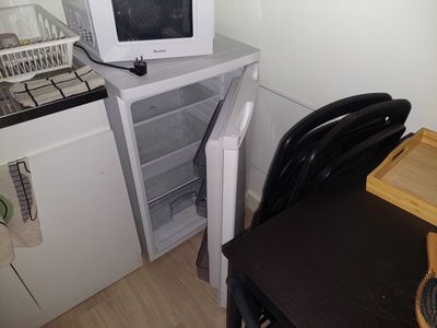 a microwave sitting on top of a refrigerator in a kitchen
