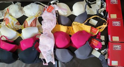 many bras that are lined up together on a bed