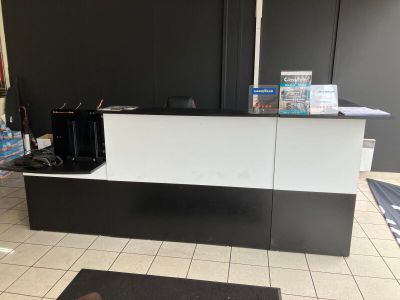 une photo d'un comptoir d'accueil noir et blanc dans un hôtel