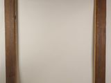 a close up of a wooden frame with a white wall in the background