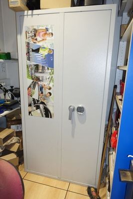 un réfrigérateur dans un coin d'une pièce où se trouvent un bureau et une chaise