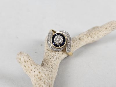 an image of a diamond and sapphire ring on a branch