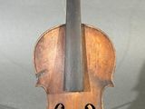un vieux violon posé sur une table près d'un mur