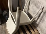une pile de chaises en plastique blanc posées sur une palette