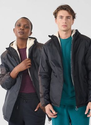 deux personnes debout l'une à côté de l'autre, vêtues d'une veste et d'un pantalon