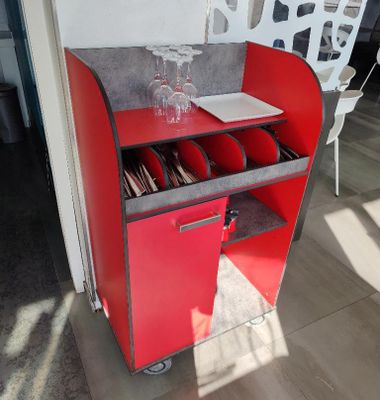 une armoire rouge sur laquelle est posé un verre à vin