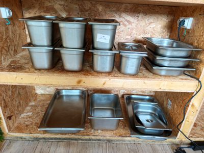 de nombreuses casseroles et poêles rangées sur une étagère dans la cuisine