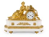 une horloge dorée et blanche sur laquelle figure une femme