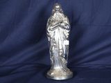 statue en argent représentant une femme tenant un enfant dans ses bras, sur fond bleu