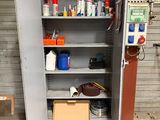 une armoire métallique contenant des outils, avec une boîte posée devant