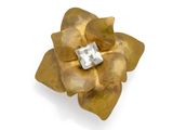 an image of a gold flower brooch with a diamond in the center