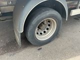 a truck with a flat tire parked on the side of the road