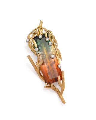 an image of a broochle with a green and orange stone