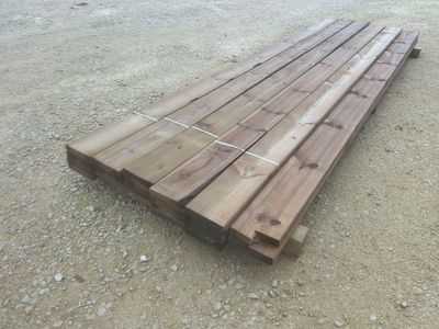 un tas de bois posé par terre, dans la poussière