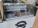 a counter with a glass display case in the middle of the room