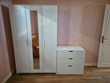 une photo d'une chambre aux murs roses et aux meubles blancs