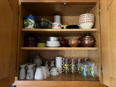 de nombreuses tasses et mugs sur les étagères de la cuisine