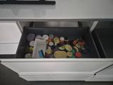 a drawer full of buttons and other things in the kitchen