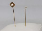 a pair of pearl and gold earrings on a white pillow