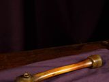 a glass of wine and a wooden stick on a purple cloth