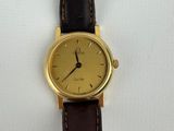 an image of a gold wrist watch with a brown leather strap