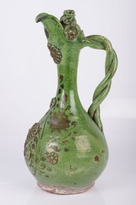 un vase vert posé sur une surface blanche