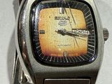 gros plan d'une montre sur un bracelet métallique