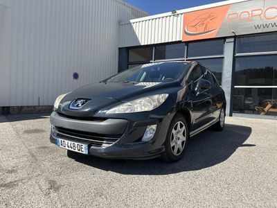 Une voiture noire est garée devant un immeuble.