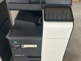 Plusieurs imprimantes de bureau sont empilées les unes sur les autres dans un entrepôt