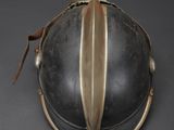 a close up of a helmet on a table with a black background