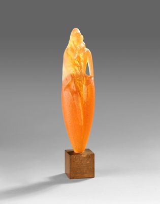 an orange jade carving of a woman on a wooden base